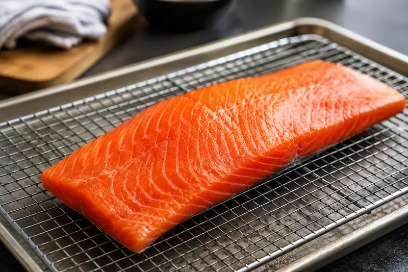 Salmon drying on a wire rack to form a pellicle before smoking